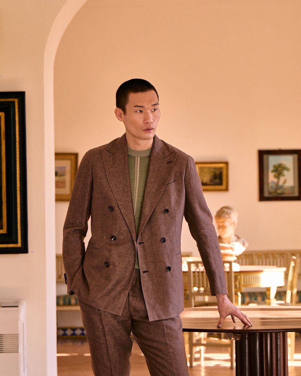 a mid-waist portrait of a well-dressed man in an antique home posing casually